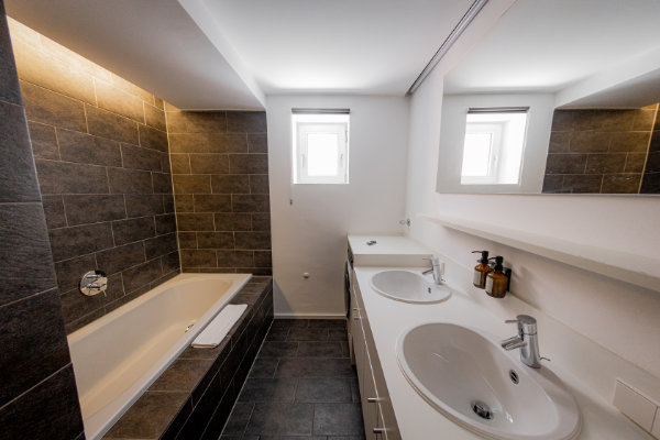 Modern bathroom with bathtub and double washbasin