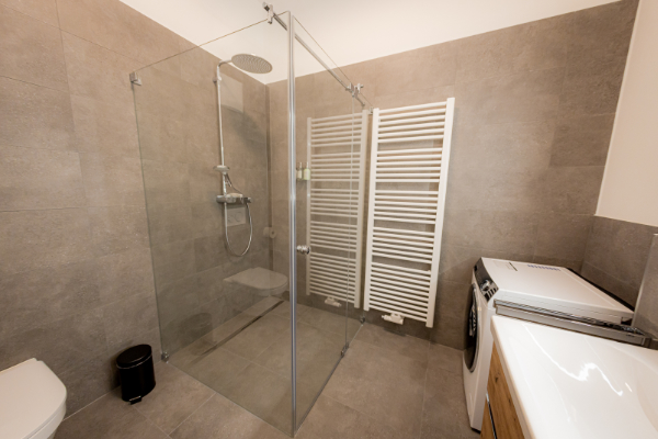 Bathroom with double washbasin, hairdryer and cleaning products - Vacation apartment Passau - BONNYSTAY