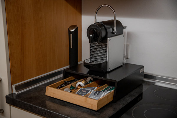 Moderne voll austgestattete Küche mit Nespresso-Maschine und Kaffepads