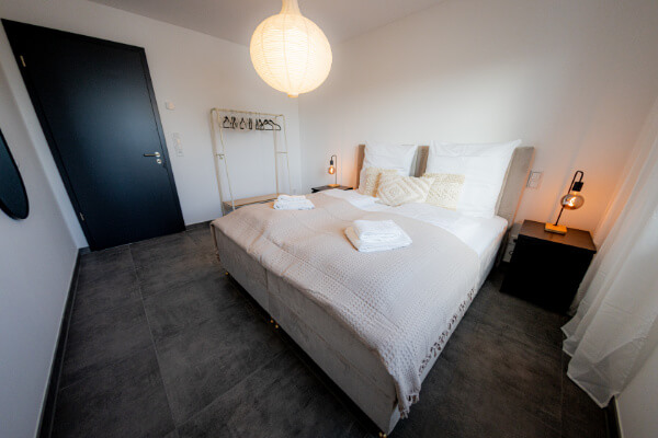 Schlafzimmer mit Bettwäsche - Apartment Herzogenaurach - BONNYSTAY