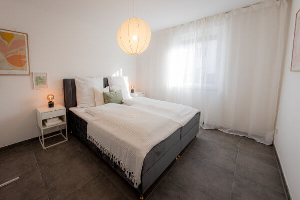 Schlafzimmer mit Kingsize-Bett im Apartment in Herzogenaurach